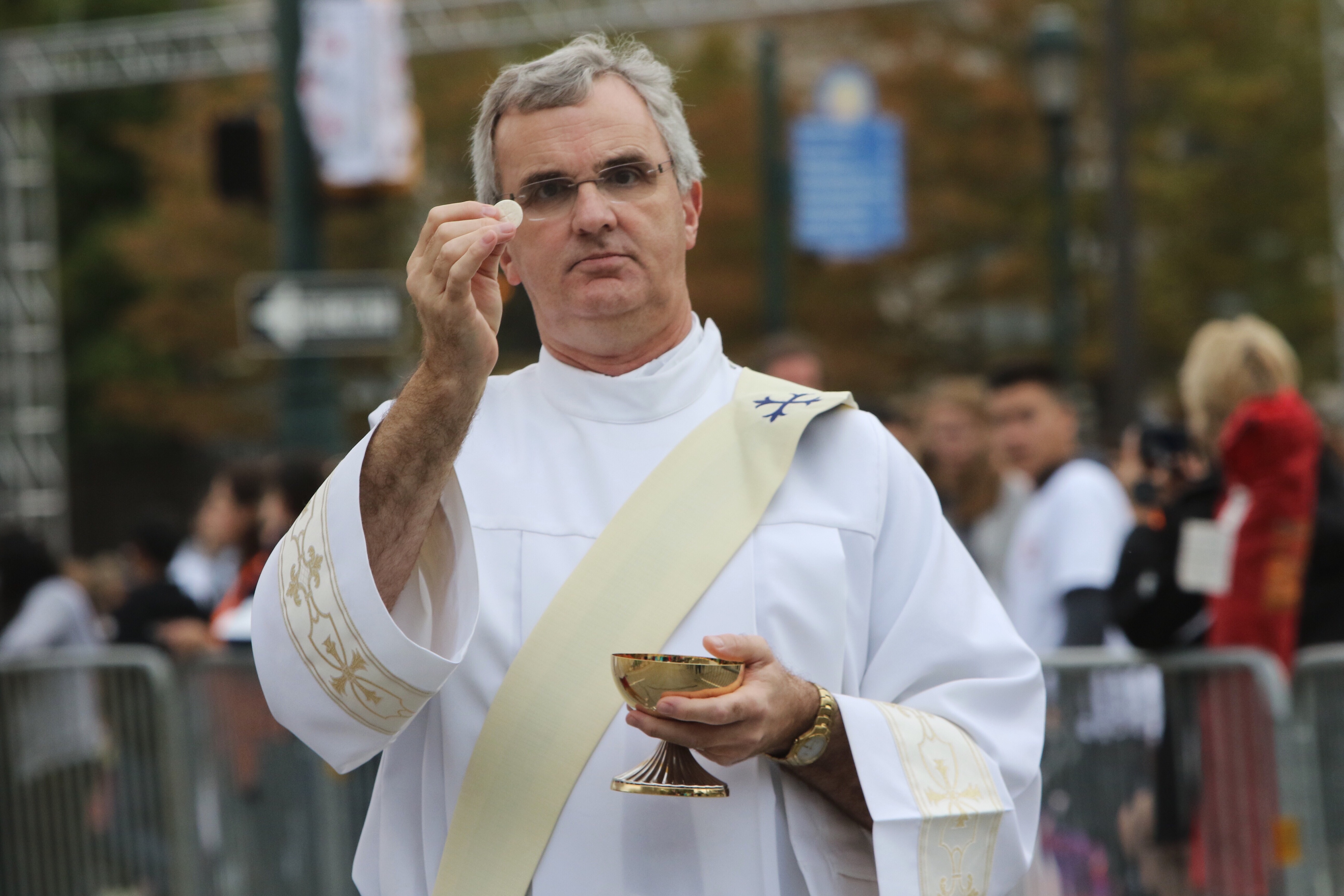 Priests travel down the parkway to give communion to the faithful lining the streets to witness Pope Francis' mass Sunday.