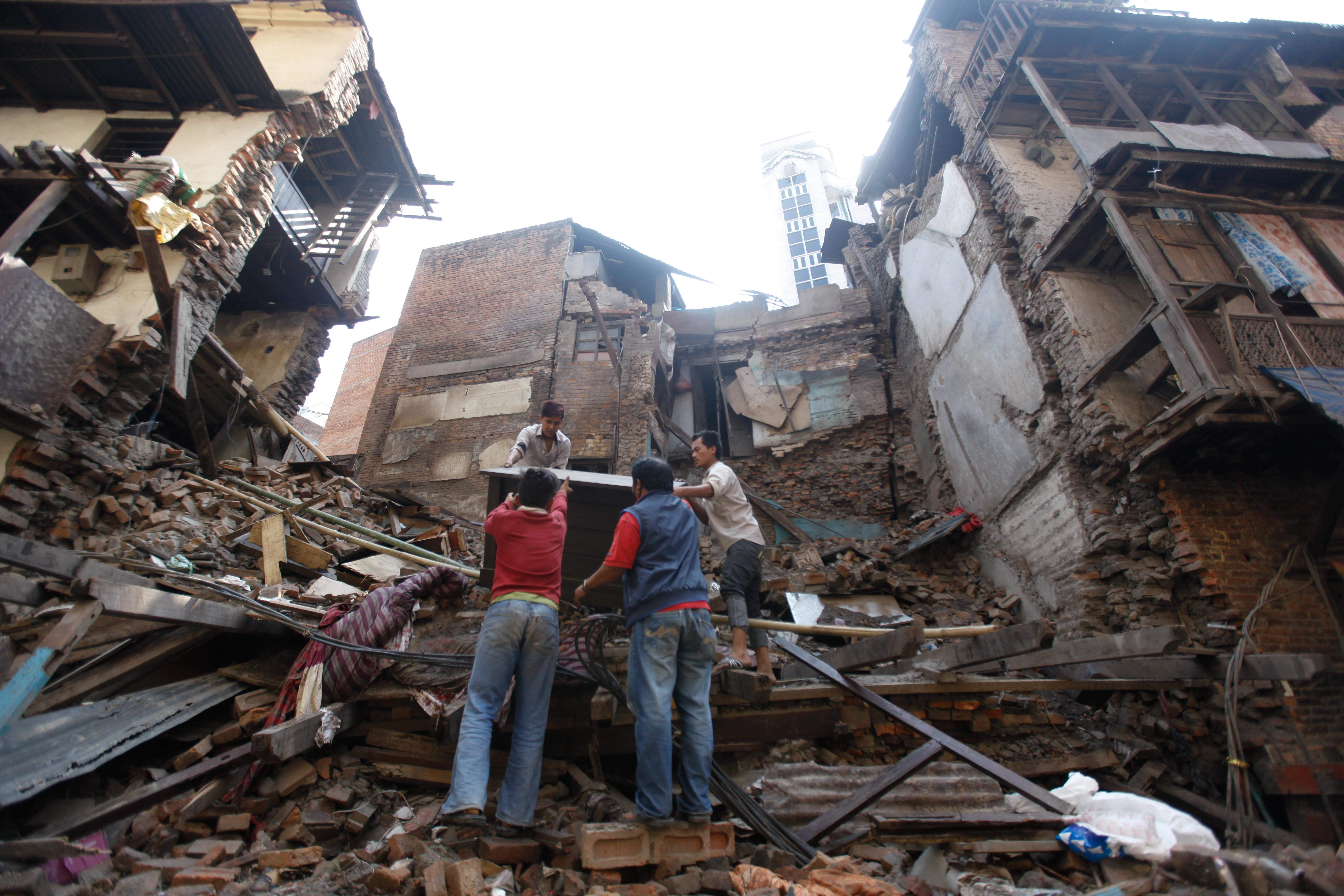 Workers salvage a desk from a collapsed building in Kathmandu, Nepal Monday, May 11, 2015.